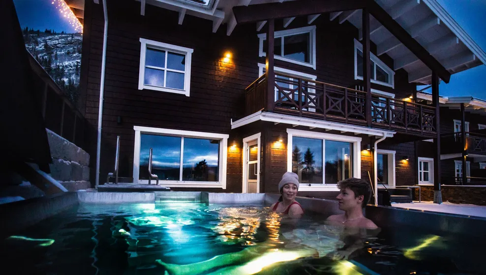 Två personer sitter i spa-pool utomhus.