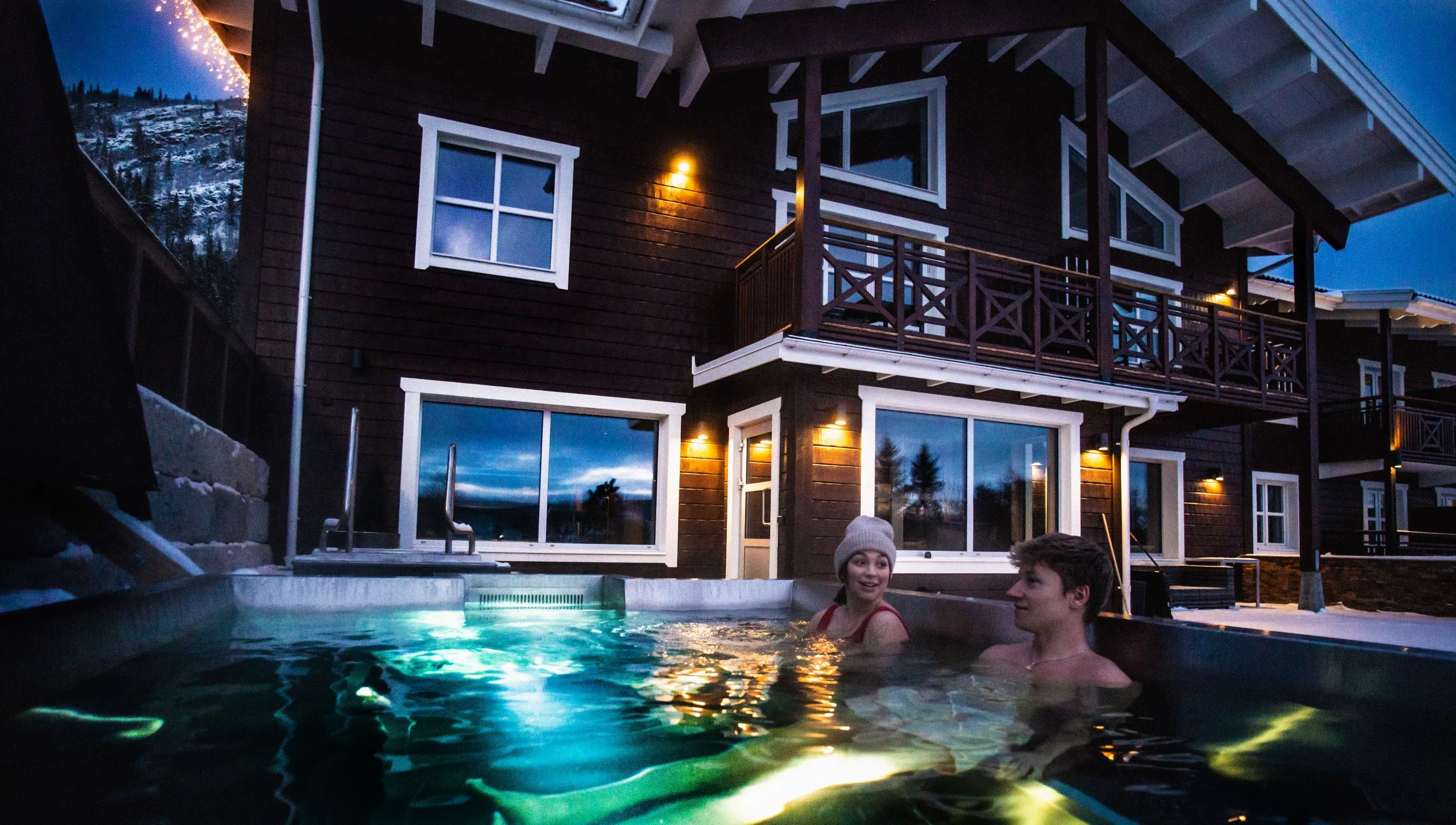 Två personer sitter i spa-pool utomhus.