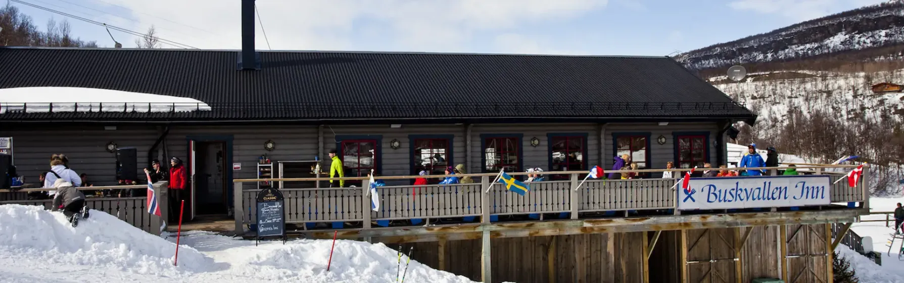 Människor på Buskvallens Inn veranda vintertid.