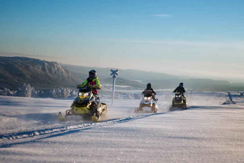 Tre personer åker skoter i Funäsdalen