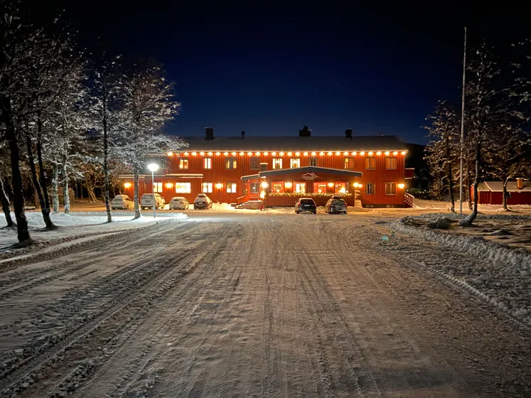 Bruksvallarnas Fjällhotell på kvällen, med belysning och snöig uppfart.
