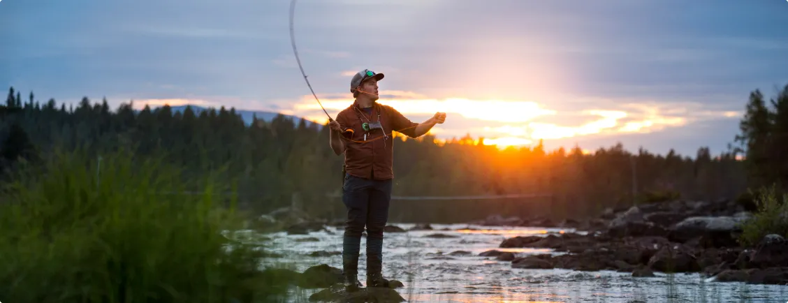 Man flugfiskar i strömmande vatten