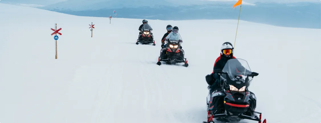 Skotrar åker på fjället med guide