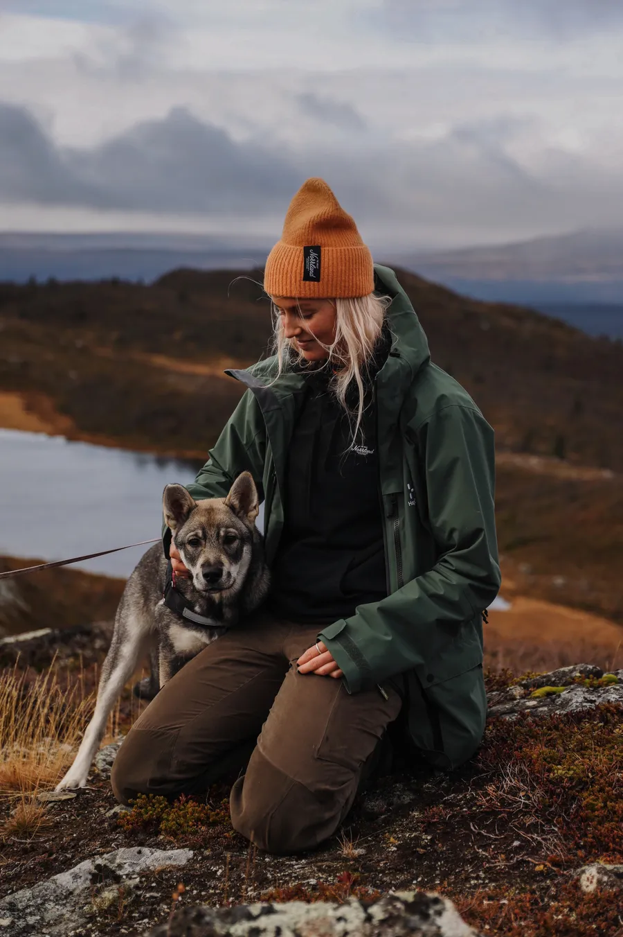 Kvinna är ute och vandrar på fjället med sin hund